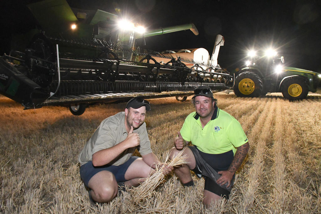 Getting as much crop harvested on Tuesday night before expected rain on Wednesday, Anthony Wilken and Pete Michell stop for the Herald camera and give a thumbs up to great harvesting.