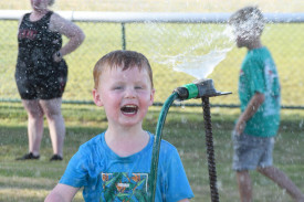 The place to be for a cool down, Harry Holland 2, found the sprinkler with his friends, a pretty cool place to be at the racecourse on Sunday evening.