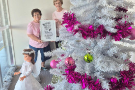 Jenny Stewart and Heather Pilgrim in their finished window at Commonwealth Bank in Scott Street. The poster details the story of the angel.