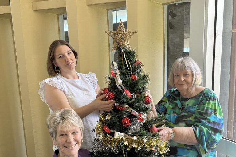 Mandy Kirsopp, Sally Mewett and Fran Robinson decorate the Christmas tree as they get into the festive spirit. Photo: CAITLIN MENADUE