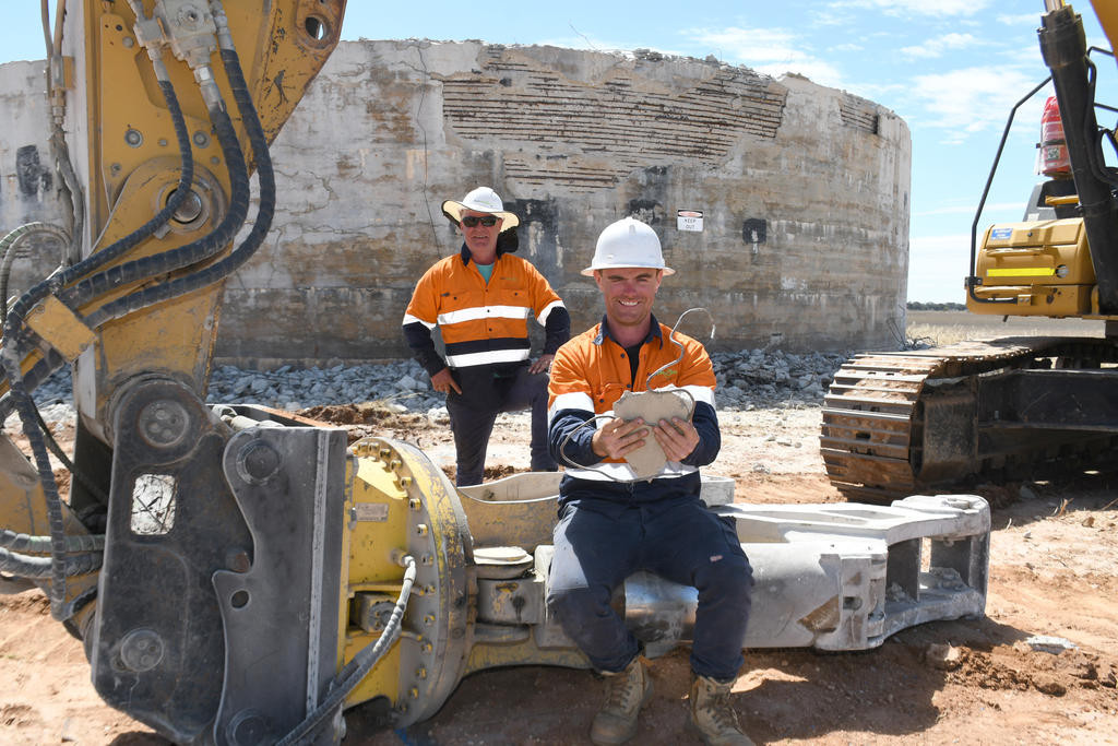 Ausdecom contractors Jonathon Miles and David Clarke are pictured with the giant jaws of the demolition equipment called a ‘combo-cutter' as they finish for the day on Monday afternoon. Photo: DAVID WARD