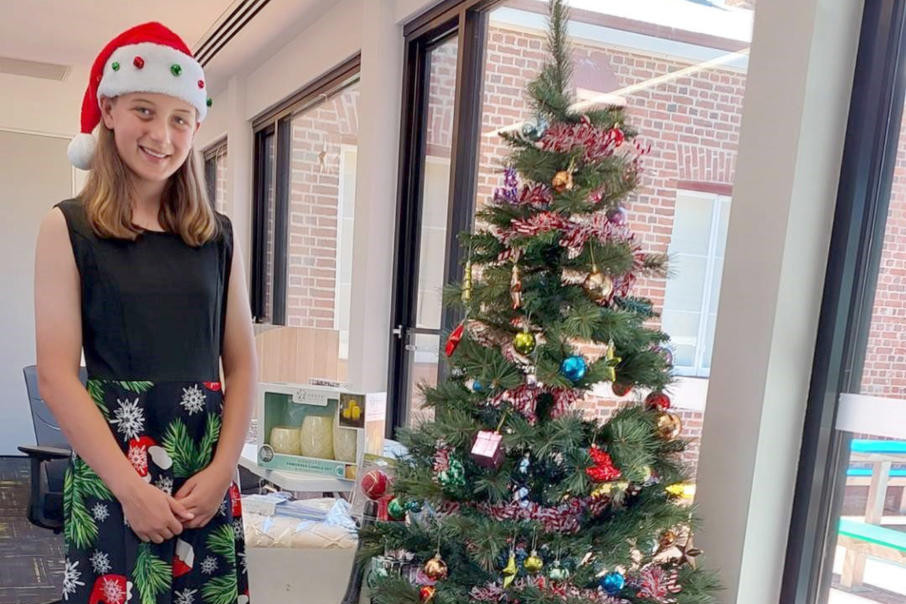 Chelsea, now 12, stands proudly in front of Hindmarsh Shire's Christmas Giving Tree. Her idea, born in Dimboola just over a year ago, has inspired the donation of 231 gifts this year, bringing joy to local families in need.