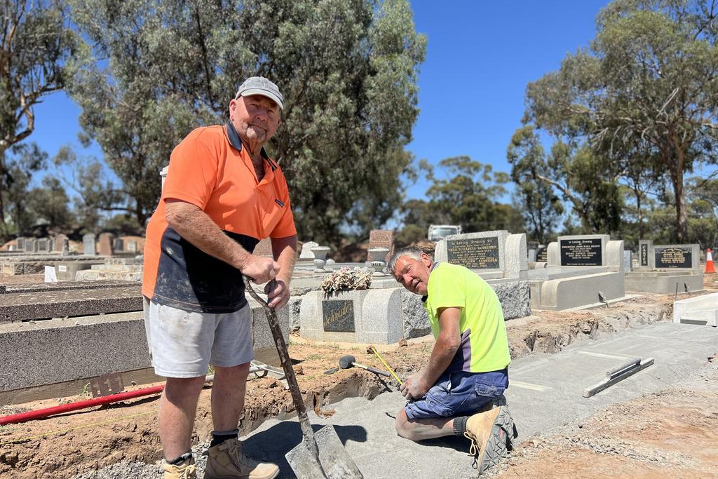 Marv Duncan and Colin Stark work on the Warracknabeal Cemetery's curbs and channels, and a new grave site during the expansion project. Photo: TAYYAAB MASROOR