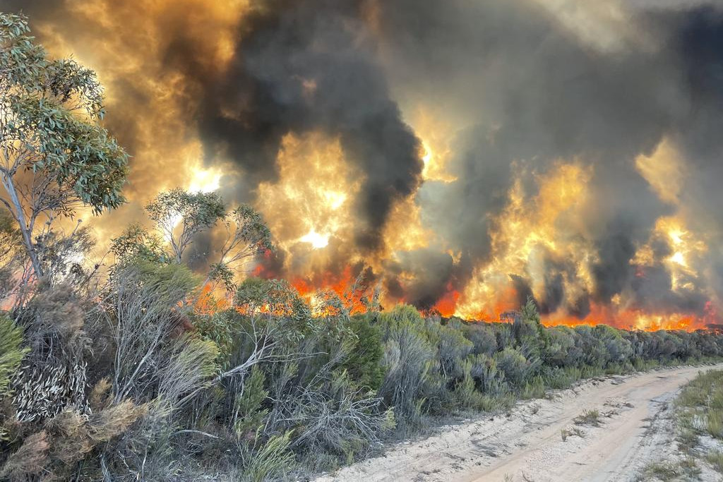 Smoke lingers over the burnt landscape of Little Desert National Park as emergency crews worked to secure containment lines.