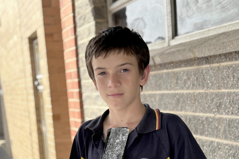 Archie Nikkelson with his damaged phone. Photo: CAITLIN MENADUE