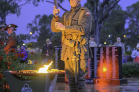 The torch is lit by young Justin Stephens.
