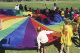Younger students play with a colourful parachute during the annual athletics carnival.