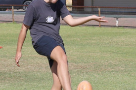 Bella Spokes kicking a football.