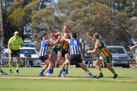 Dimboola’s Andrew Moore is swamped by three Minyip Murtoa players during the opening centre bounce.