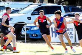 Kalkee’s Aiden Richardson is about to be tackled by Laharum’s Monty Wynne while Hayden Kemp waits for the ball to spill.
