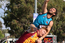Jake Garvey punches the ball clear of Kyle Cheney. Both players were named among the best for their teams.