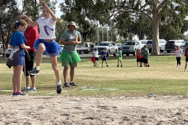 Esmae jumps high during triple jump.