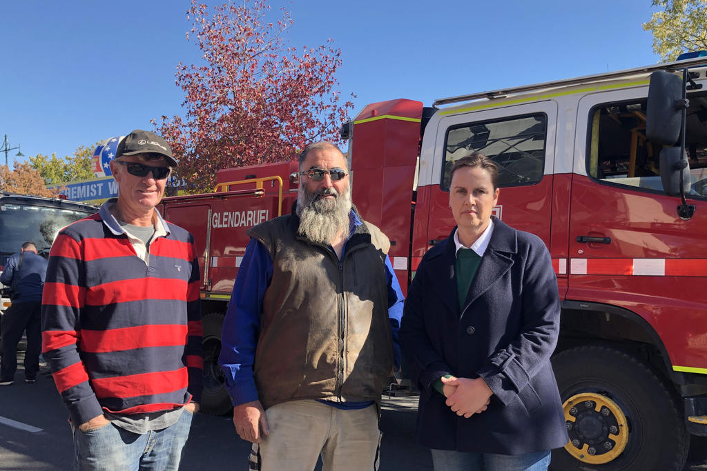 Gaelle Broad with CFA volunteers Andrew and Adam at the protest outside Premier Jacinta Allan's office.