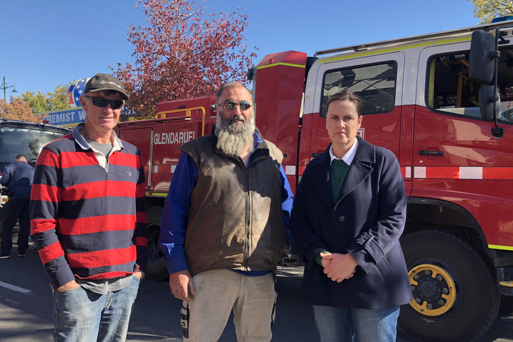 Gaelle Broad with CFA volunteers Andrew and Adam at the protest outside Premier Jacinta Allan's office.