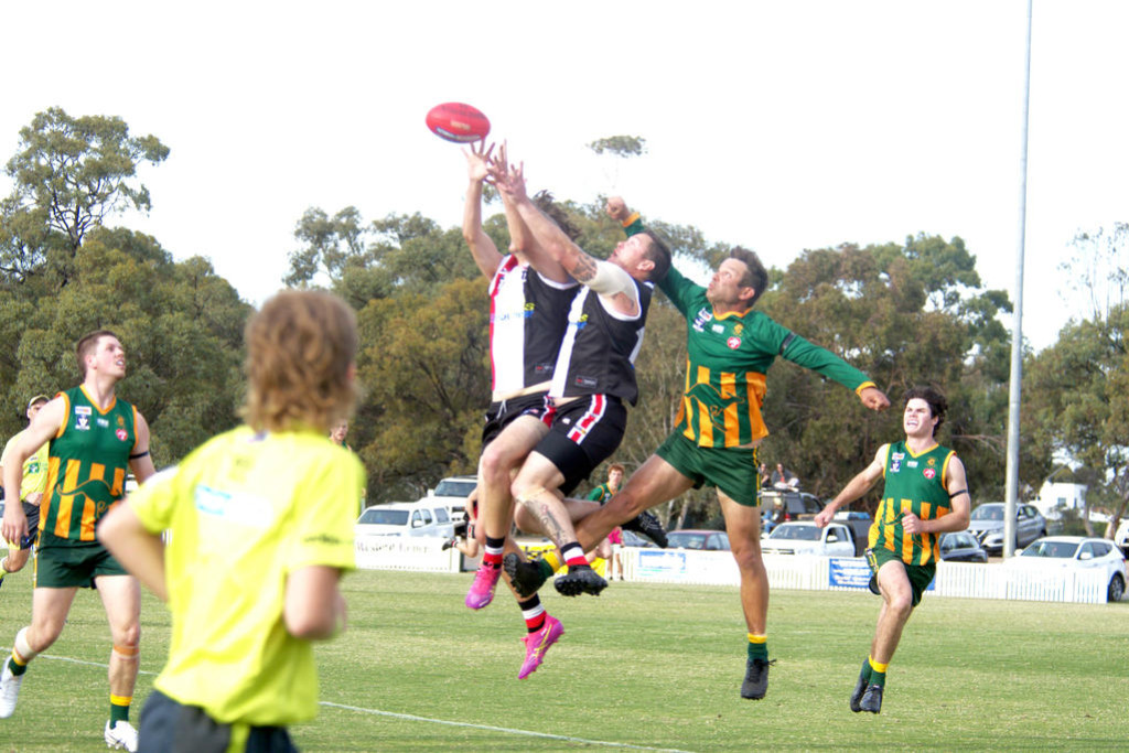Dimboola's Ash Clugston, attempts to spoil a mark of Jessie Taylor (front) and Nathan Koenig from Horsham Saints