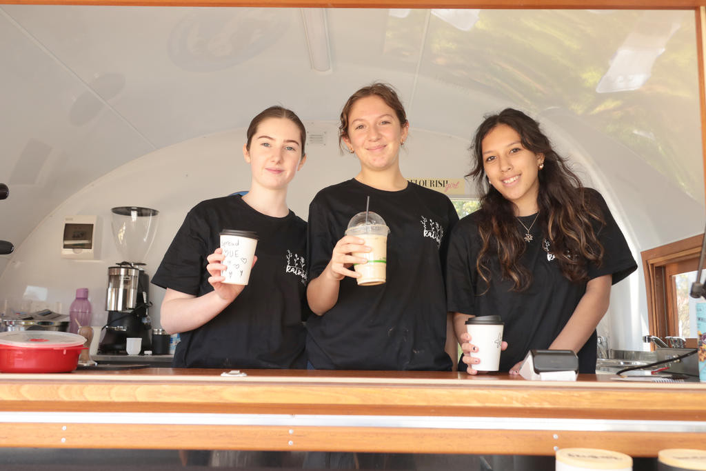 Rainbow P-12 College Year 12 students Nekeisha, Lilly, and Chantelle serve coffee, iced drinks, and food every Tuesday as part of their PDS class project. By the end of the school year, the students will continue to run the van each week.