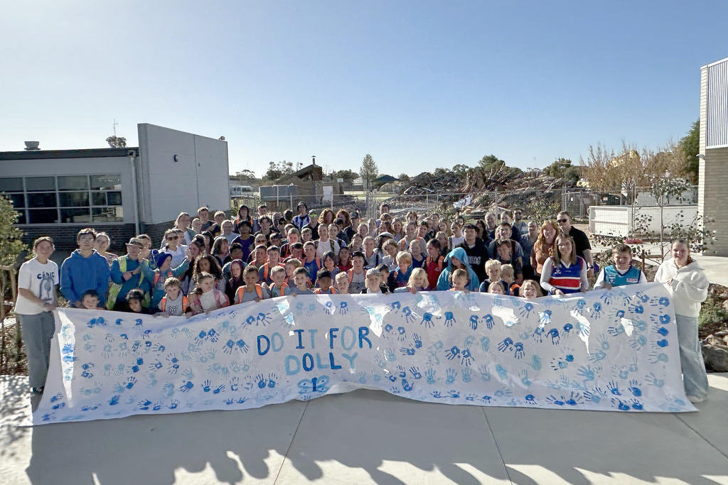 The entire school community with the sign they made.