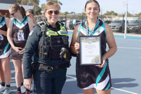 Senior Constable Marie Doolan presents a Spirit of Netball award winner to Amara Jagan.