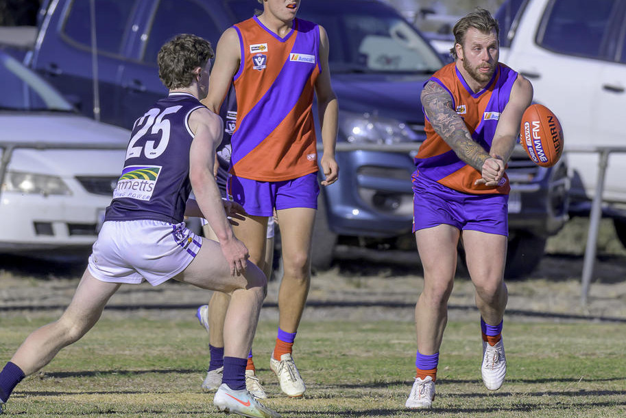 Kalkees's Seth Thompson delivers a handball.