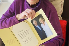 Claire McKenry proudly shows her message from the King on her 100th birthday