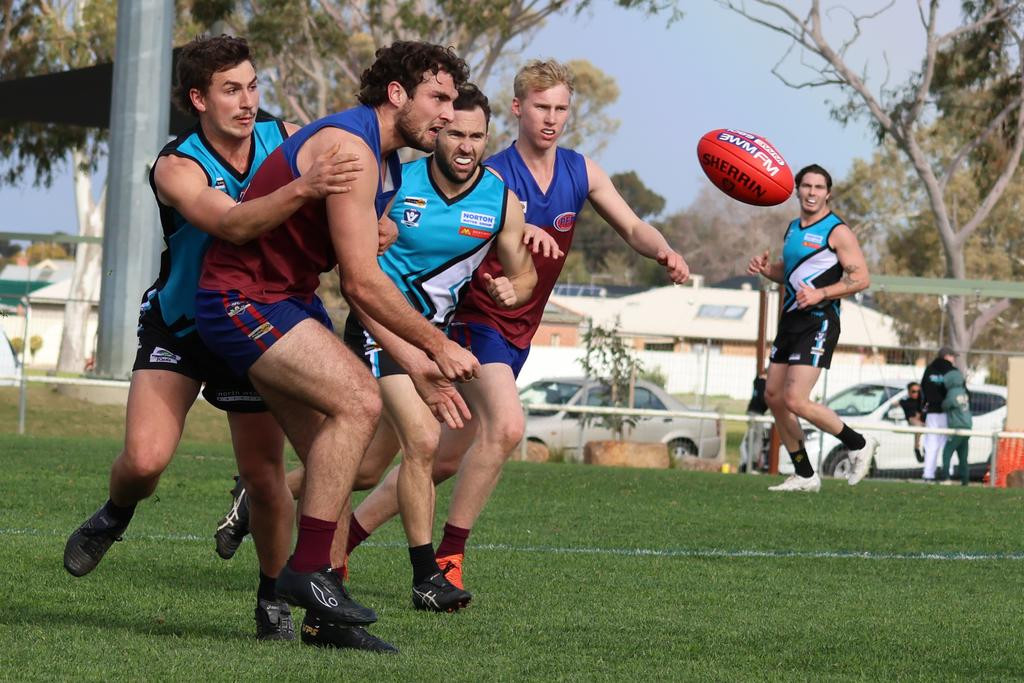 Horsham's Hudson Hair gets a handball away.