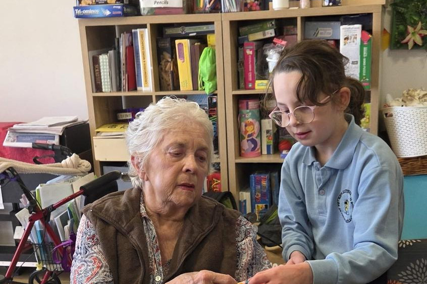 Isabella helps fit a friendship bracelet.