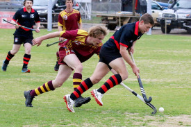Hurricanes’ Traiyth Leffler runs with the ball while Hoops’ Heath Johns attempts to spoil.