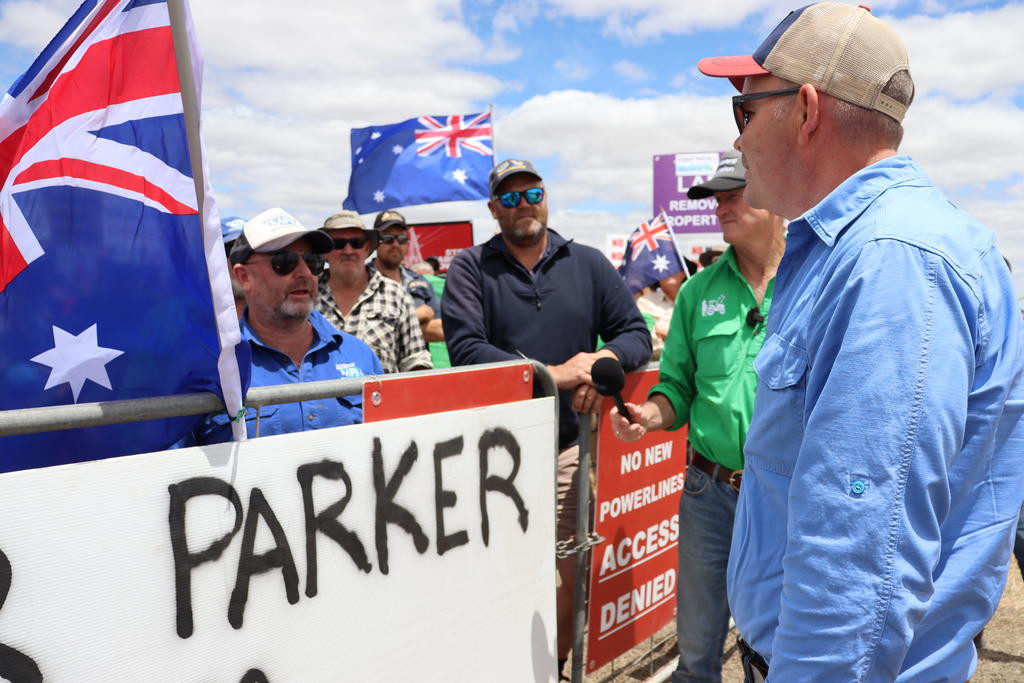 VicGrid personnel were denied access by hundreds of farmers at Ben Duxson's gate. Ben Duxson (left) talking to VicGrid personnel (right).