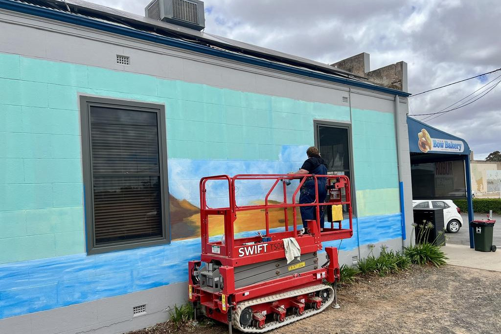 Local artist Belina Eckermann is painting a new mural on the side wall of the Bow Bakery in Rainbow.