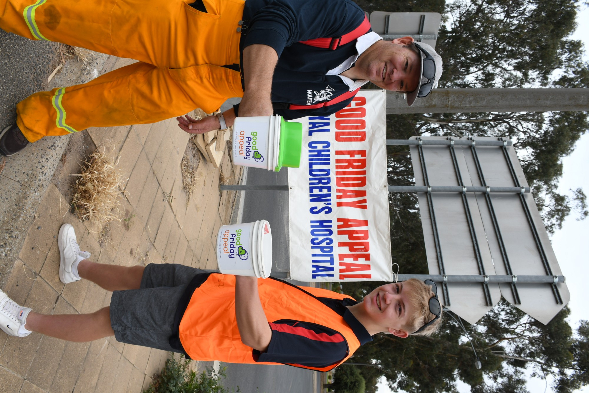 BUCKETS OF GOOD WILL: Father son duo Craig and Angus Byron stand on the Rainbow Road, Kelsall Street intersection in the early hours of Good Friday. Photo: DAVID WARD.