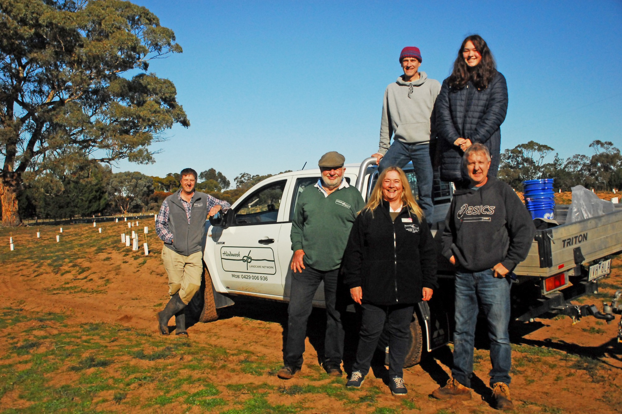 (Back) Gary and Hannah Spivak from Melbourne, with (left-right) Landcare Hindmarsh facilitator Johnathan Starks, Chairman Cliff Unger, Hindmarsh Shire councillor Wendy Bywaters, and property owner Andrew King out watering over 10,000 trees, shrubs, herbs and grasses that were planted during last year's Project Hindmarsh weekend in Dimboola.