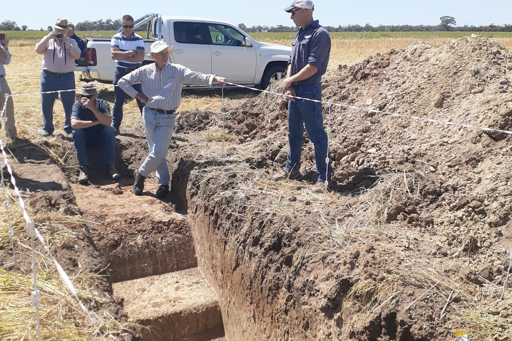 Shannon Byron (right) shows conference attendees the soil pit, discussing the difference between his aerated and non-aerated sections.