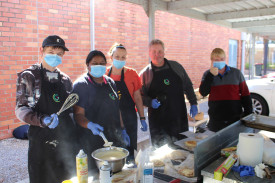 COOKING UP A STORM: The Uniting Wimmera disability team working hard by the barbeque to cook more than 300 pancakes for the event. Photo: ABBY WALTER. 