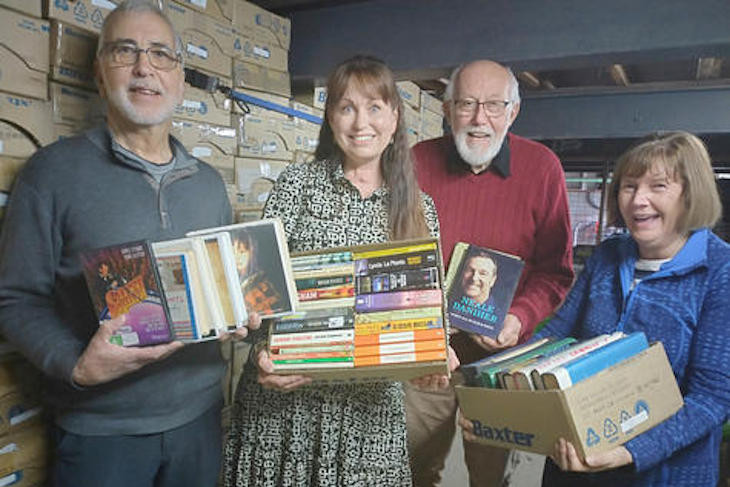 Horsham College chaplain Yolande Grosser, second left, is with book sorters John Spehr, Neville Smith and Mary-lou Spehr. Behind is a pile of boxes ready for the next fair. At the fair all books are placed on tables in boxes sorted by the three each week during school term. Photo: FAYE SMITH