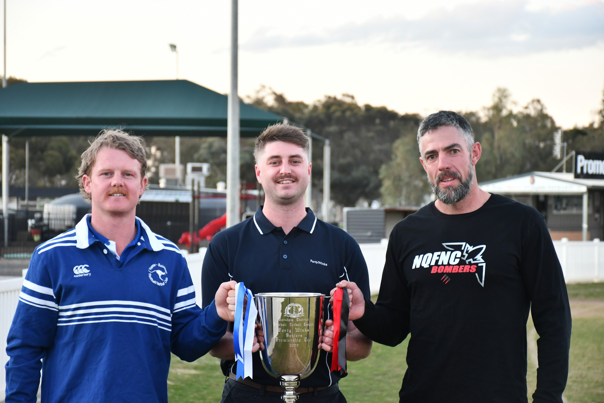 Harrow Balmoral's Will Burbury, Forty Winks Horsham's Tristan Cameron and Noradjuha Quantong's Damian Cameron holding the Forty Winks premiership cup.