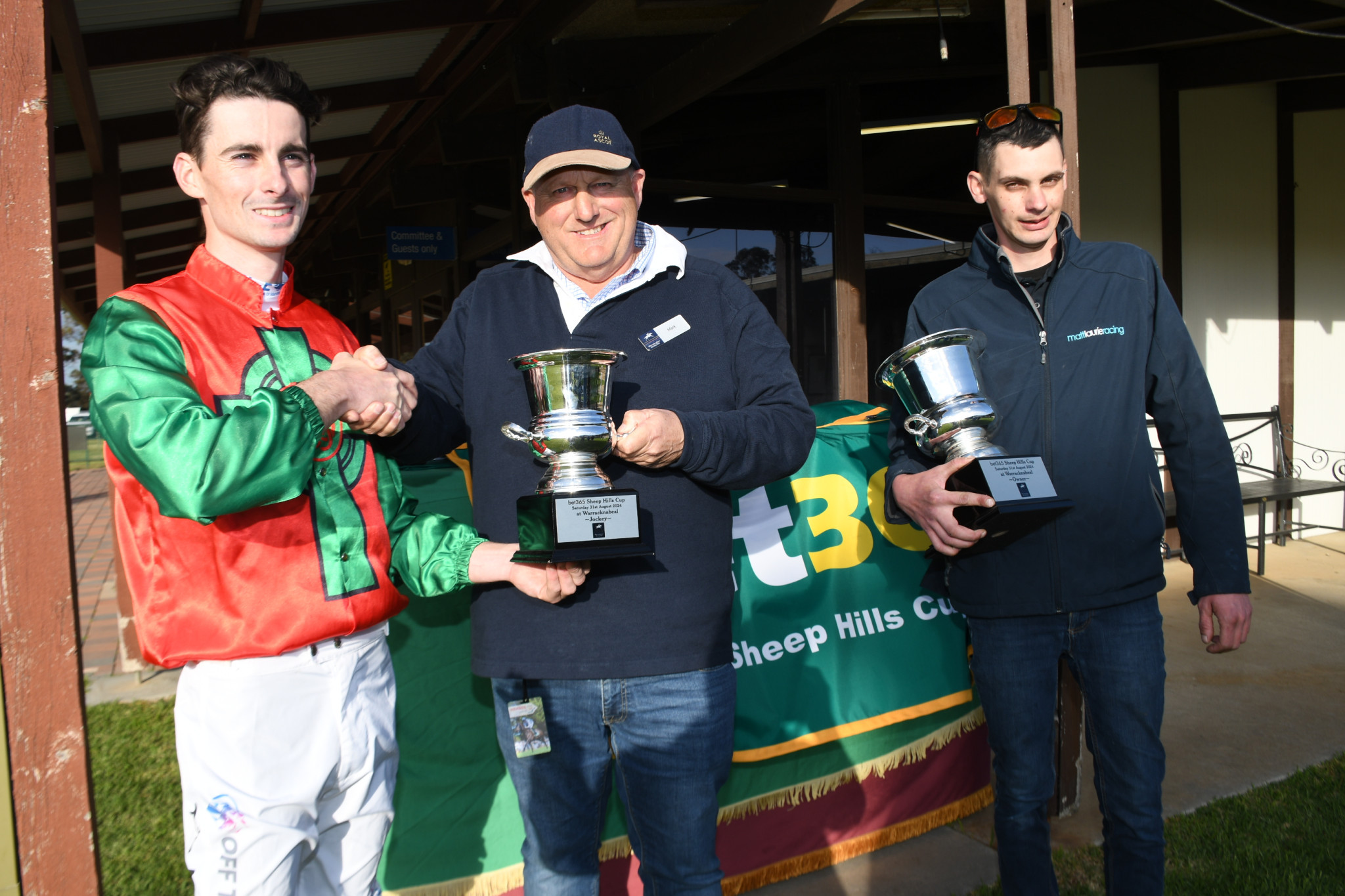 Winning jockey Teo Nugent accepts the Sheep Hills Cup from club president Mark Phelan with 'Staunch' stable representative Paul Gudgion holding the Cup. PHOTO: DAVID WARD