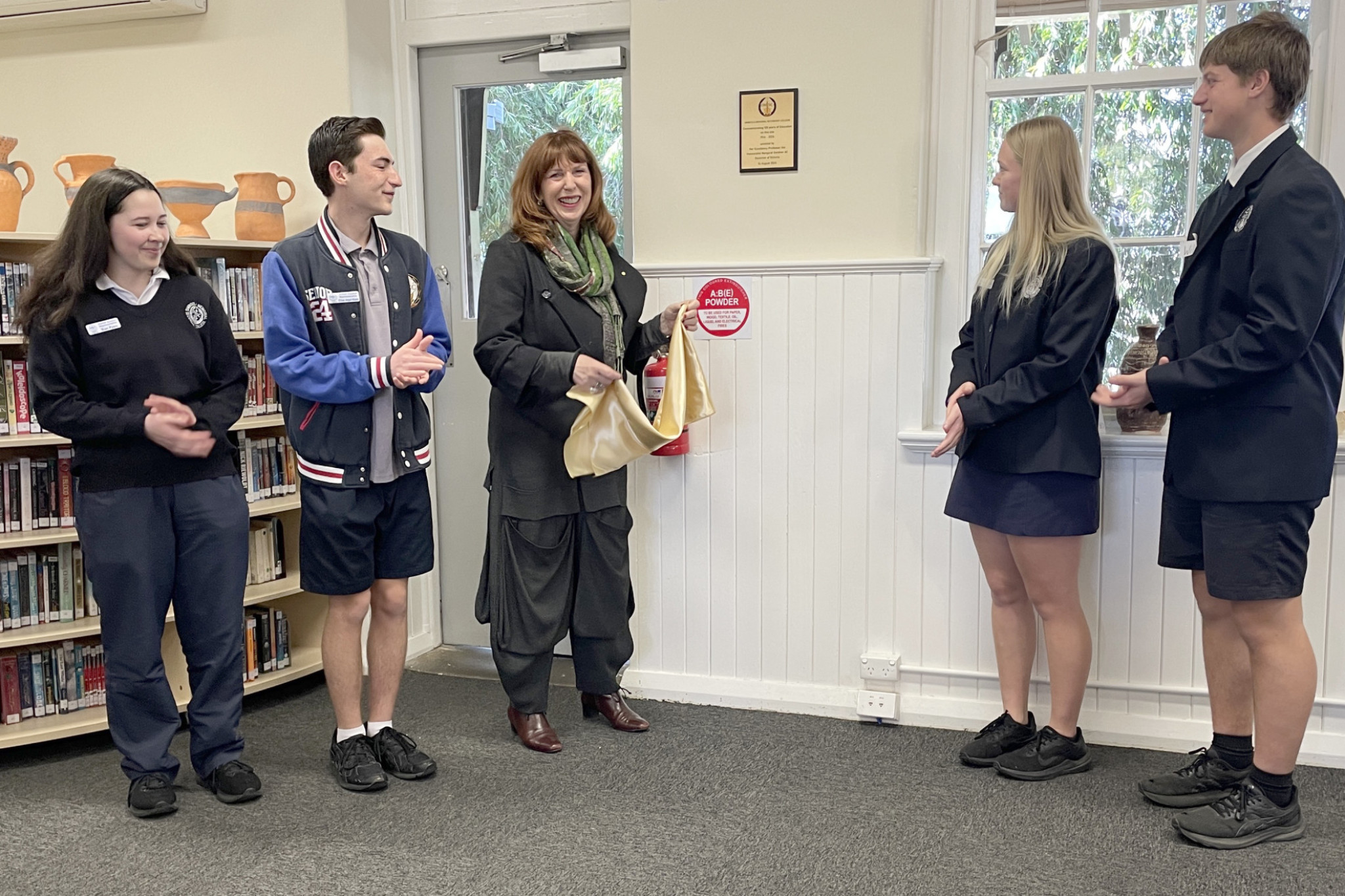 Her Excellency Professor the Honourable Margaret Gardner AC, Governor of Victoria, unveiling a plaque commemorating Dimboola Memorial Secondary College's centenary with student council representatives Rian Pyers and Ethan Angel-Hands, and school captains Katie Griffiths and Will Thomson.