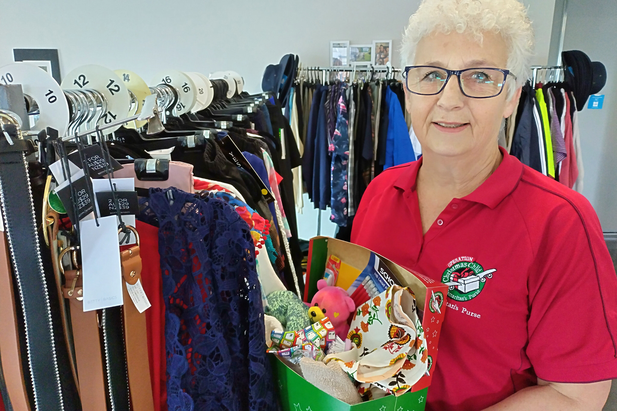 Linda Guthridge holds a Samaritan's Purse shoe box in front of her sale items.