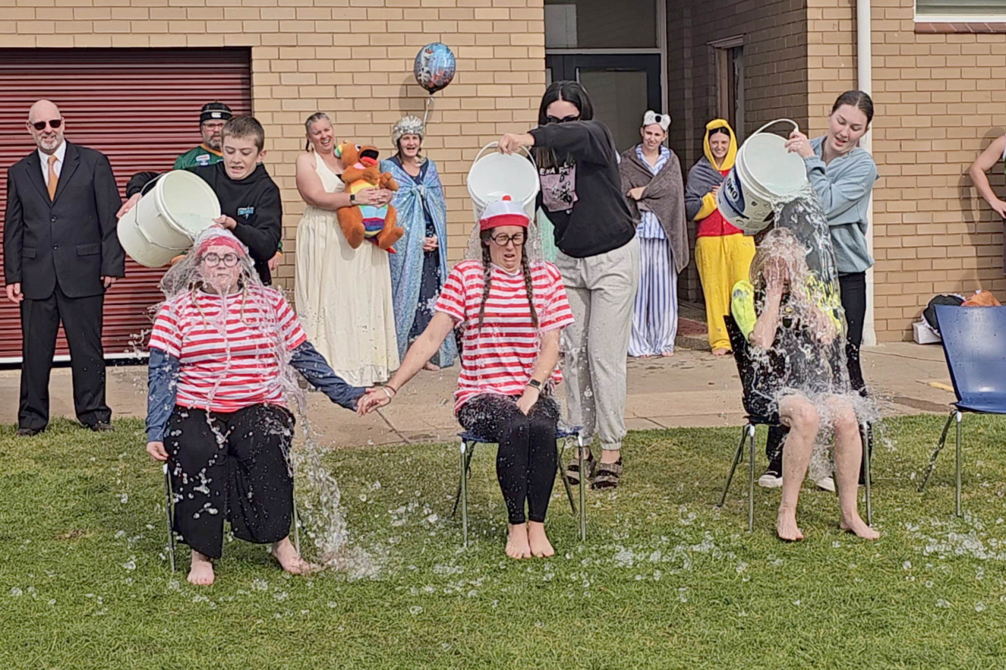 Grace Phelan and Stef Newton draw courage from each other while Moira Fulton tries to hide as raffle winners pour buckets of ice water over the 'volunteers'. With assistance from the Southern Mallee Thunder, who held their own Big Freeze event the next day, students raised $5313 to fight MND.