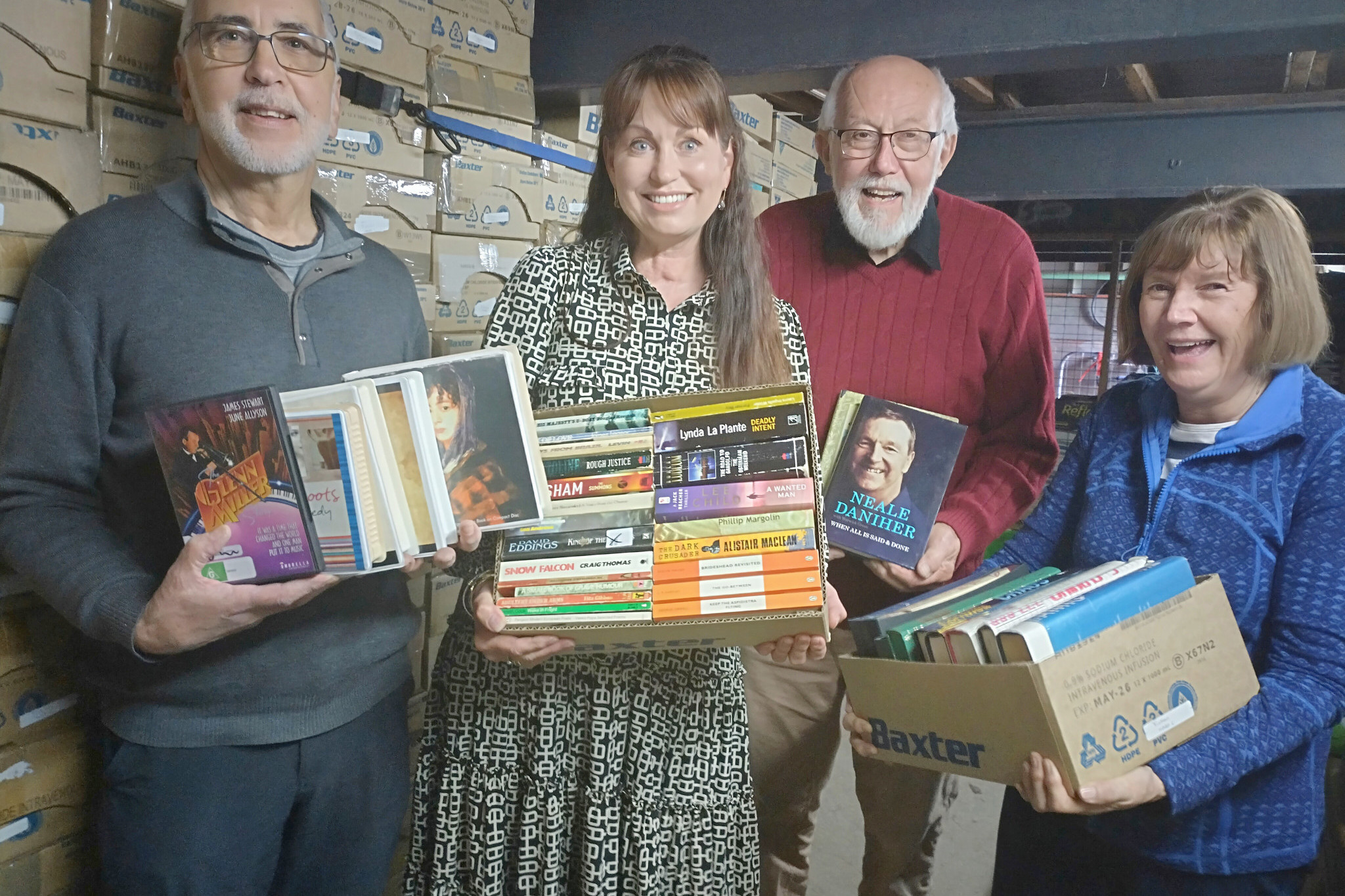 Horsham College chaplain Yolande Grosser, second left, is with book sorters John Spehr, Neville Smith and Mary-lou Spehr. Behind is a pile of boxes ready for the next fair. At the fair all books are placed on tables in boxes sorted by the three each week during school term. Photo: FAYE SMITH