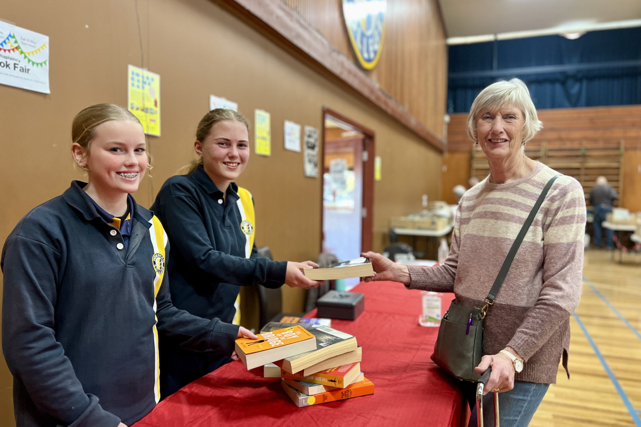 Horsham College students Lily Wearn and Stevie Clark serving one of the Book Fair customers Joan Gordon.