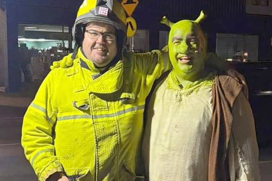 Fire fighter Joel Wills with Shrek, alias Tom O'Donnell, during the evacuation. CREDIT Claire Petering