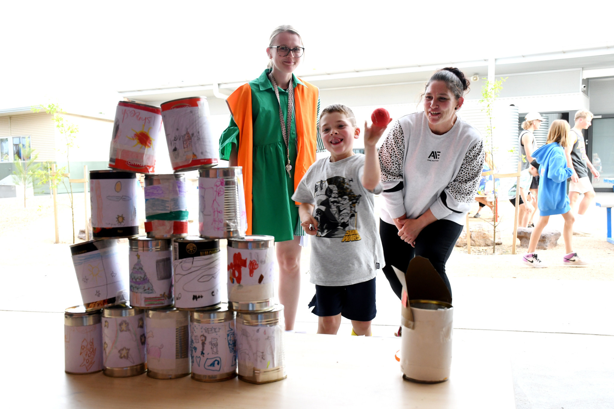 Grade 1-2 teacher Simone Clark and helper Holly Pollard help Lenny Schmidt 6 with his shot.