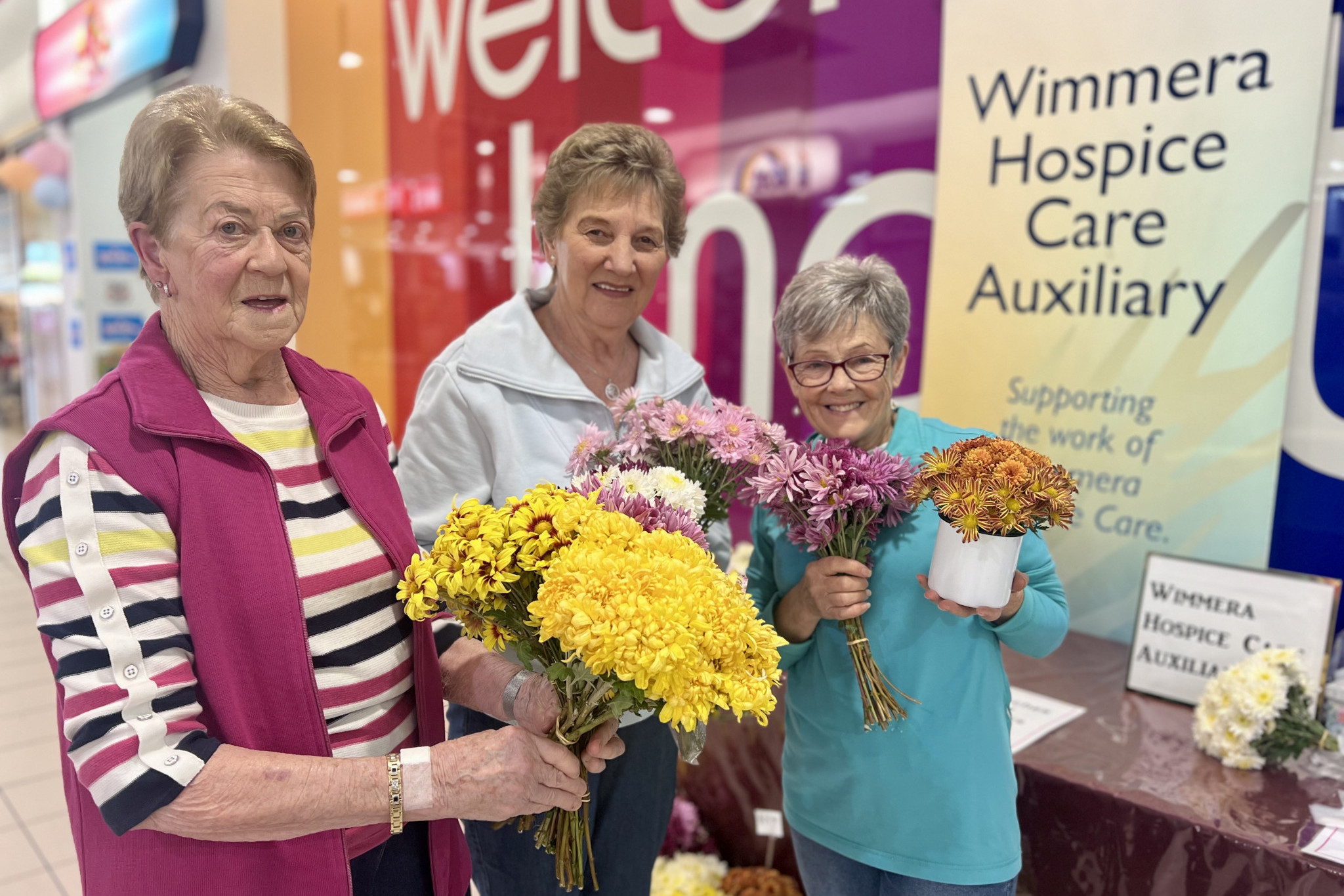 Wimmera Hospic Care Auxiliary volunteers Denise Mackenzie, Marion Seater, and Lea Crammond sold Chrysanthemum Flowers for Mother's Day last week in Horsham Plaza to raise money for their group. Photo: TAYYAAB MASROOR