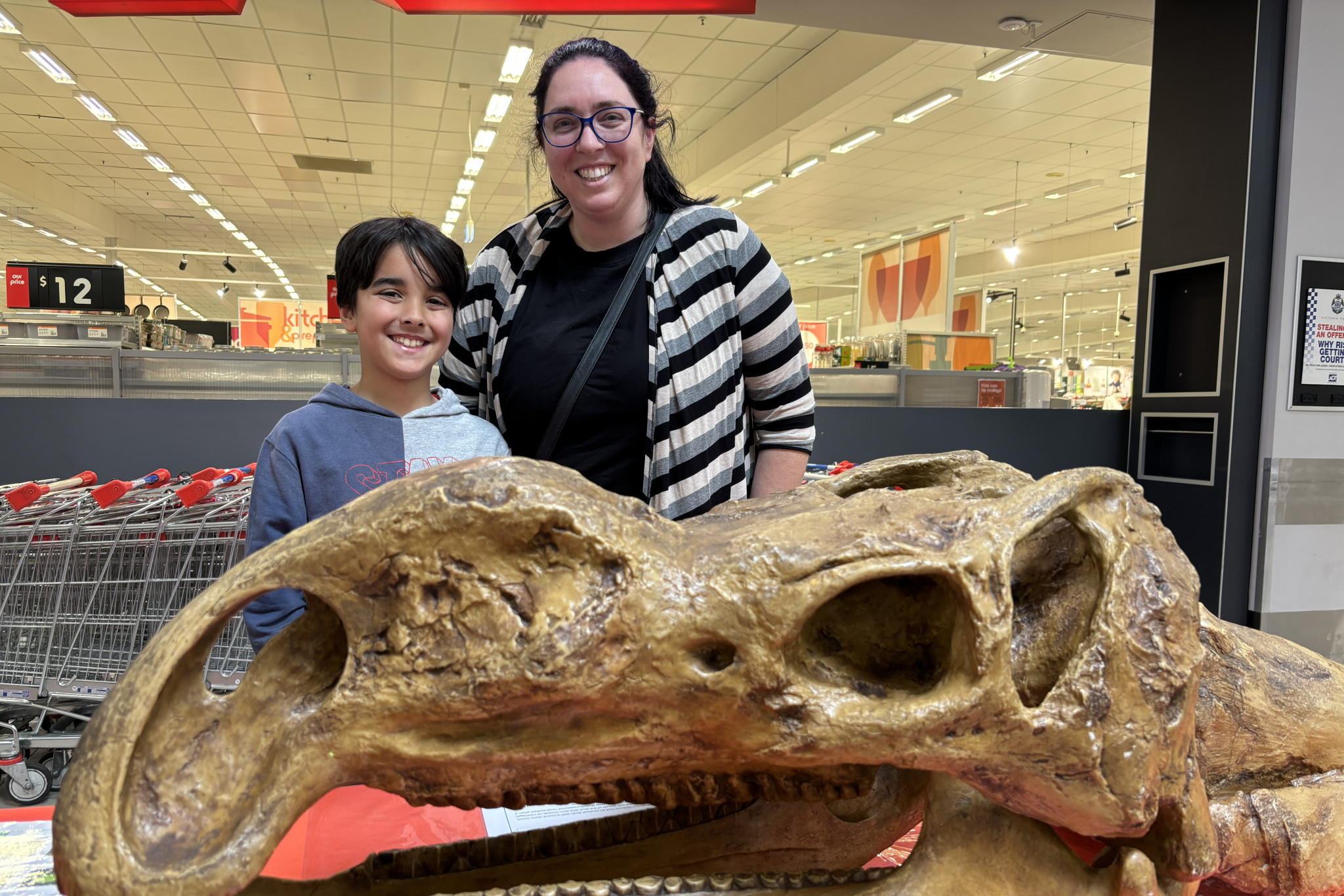 Jeremiah, 9, and Michelle Budhathoki with a life-sized Muttaburrasaurus skull. Photo: CAITLIN MENADUE