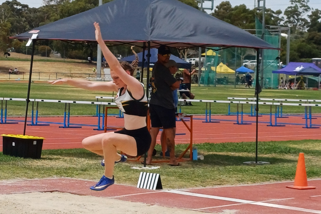 Asha Meek competing in the long jump.