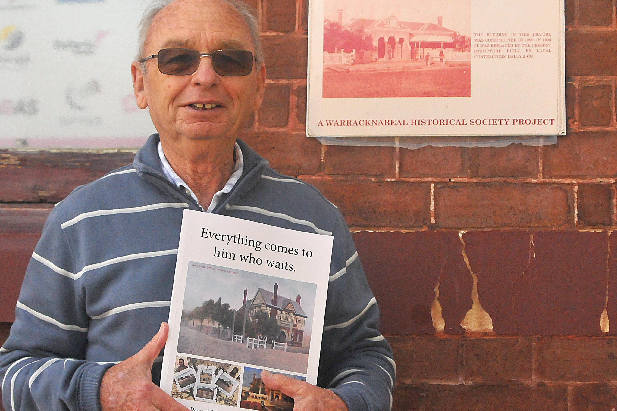 Ian Wright at the Warracknabeal Post Office with his book "Everything comes to him who waits" Photo: ANDREW WARD