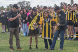 Jock Baker presenting Trent’s playing guernsey to Trent’s parents Josh and Nicole and younger brother Jamie.