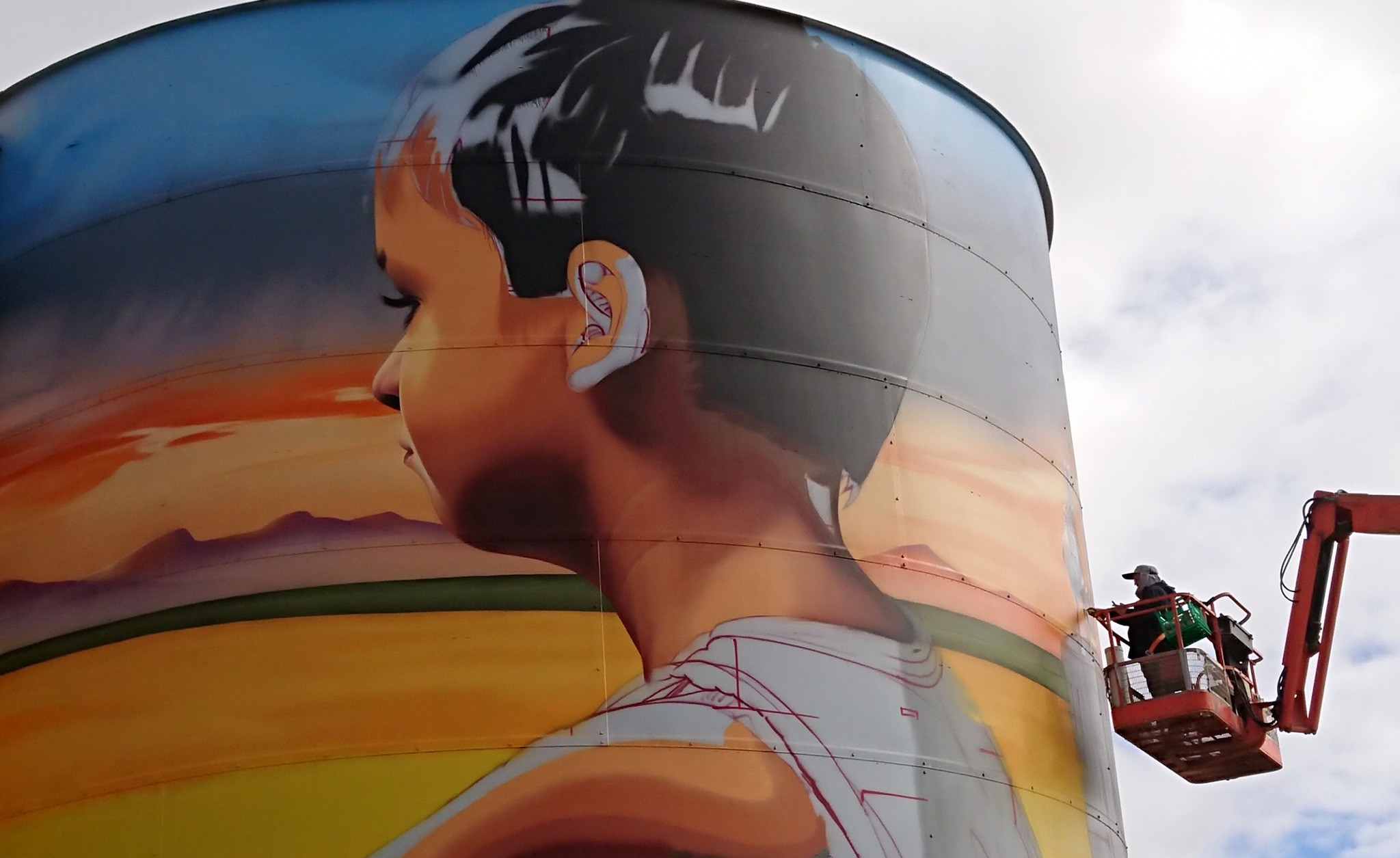 Artist Smug painting the silo.